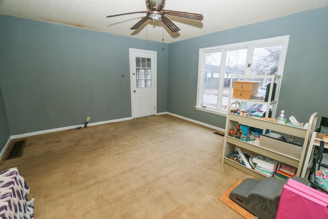 carpeted entrance foyer with a ceiling fan, visible vents, and baseboards