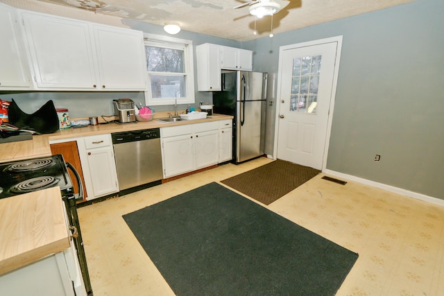 kitchen featuring stainless steel appliances, a sink, light countertops, and white cabinets