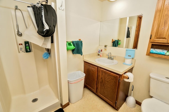 bathroom with a stall shower, vanity, and toilet