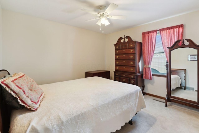 bedroom featuring ceiling fan, baseboards, visible vents, and light colored carpet