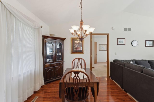 dining room featuring vaulted ceiling, dark wood-style flooring, and visible vents