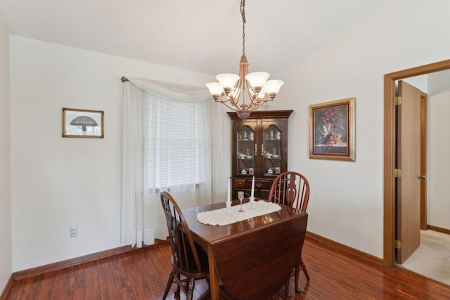 dining space featuring a chandelier, baseboards, and wood finished floors