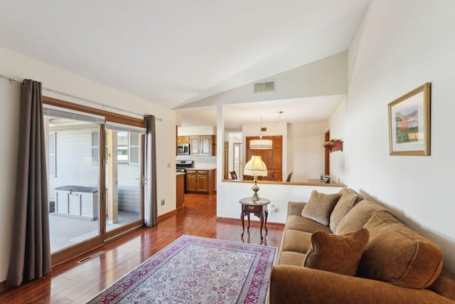 living area with lofted ceiling, dark wood-style floors, and visible vents