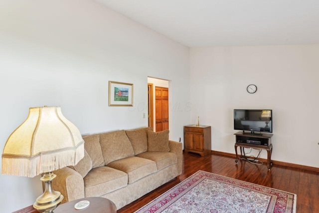 living room with vaulted ceiling, wood finished floors, and baseboards