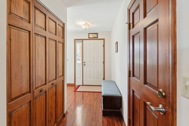 foyer with dark wood-style floors and baseboards