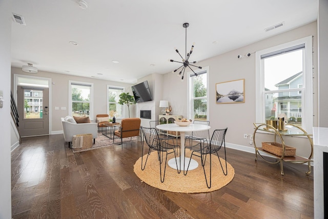 dining space with a healthy amount of sunlight, visible vents, and dark wood finished floors