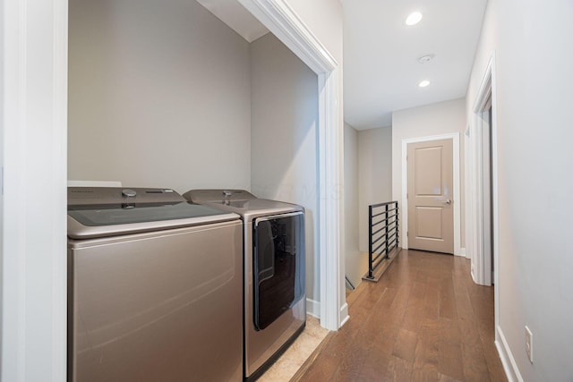 laundry room featuring washing machine and clothes dryer, recessed lighting, wood finished floors, laundry area, and baseboards