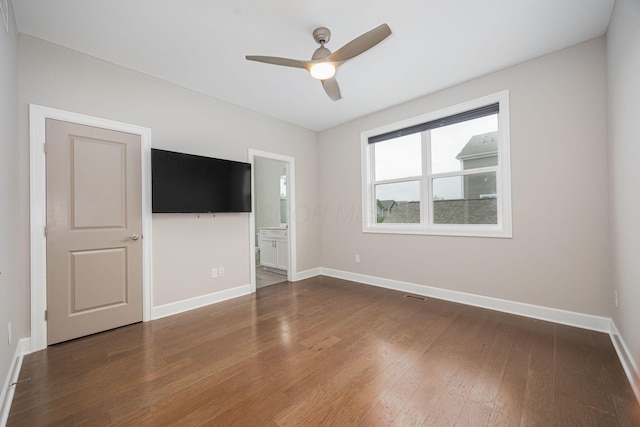 unfurnished room featuring a ceiling fan, visible vents, baseboards, and wood finished floors