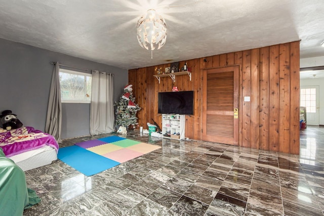 bedroom with wood walls and a textured ceiling