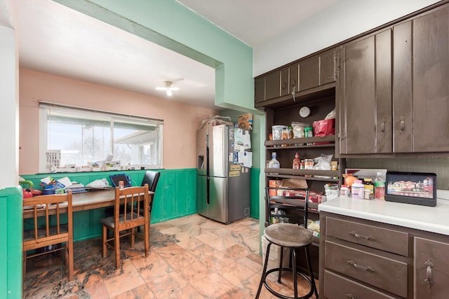 kitchen featuring dark brown cabinets, open shelves, light countertops, and stainless steel fridge with ice dispenser