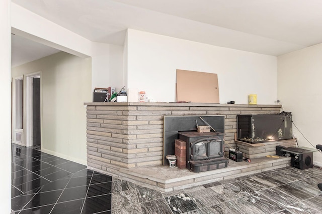 room details featuring a wood stove and baseboards