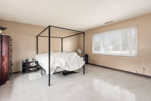 bedroom featuring speckled floor, visible vents, and baseboards