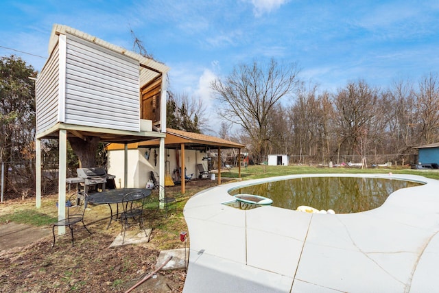 pool with fence, an outbuilding, and a patio