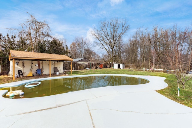 view of home's community featuring a patio area, an outdoor structure, a swimming pool, and a storage shed