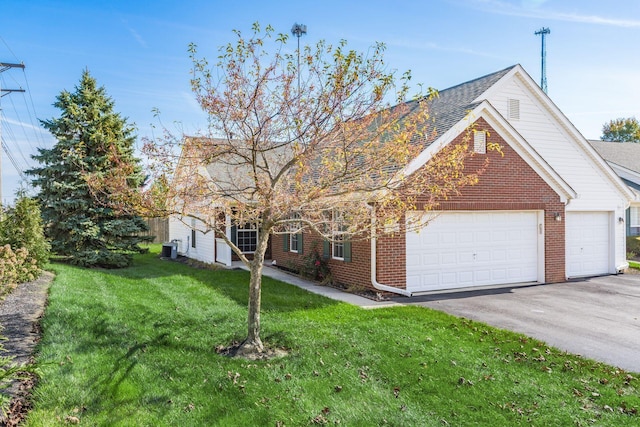 view of front facade featuring brick siding, roof with shingles, a front yard, a garage, and driveway