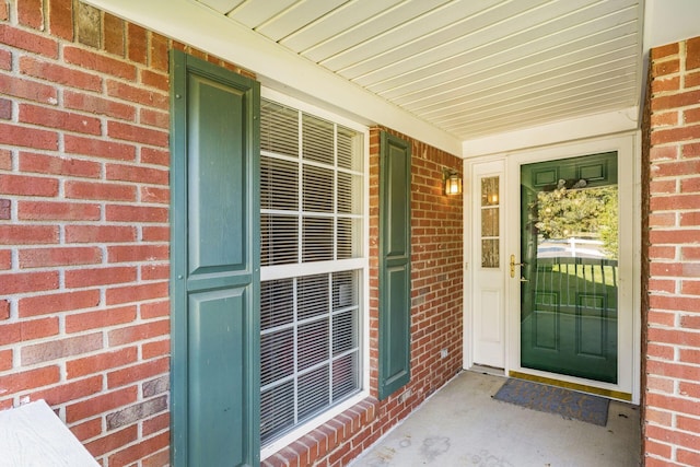 entrance to property featuring brick siding and a porch