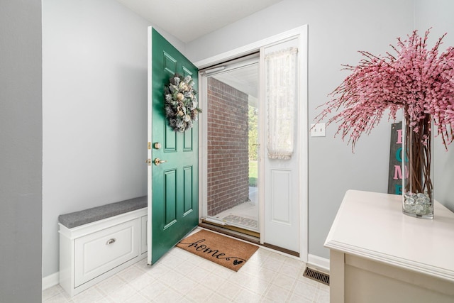 entryway with baseboards, visible vents, and light floors