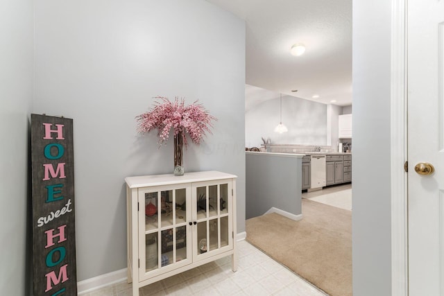 hallway featuring light floors and baseboards