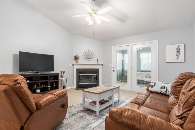 living area featuring light carpet, a fireplace with flush hearth, a ceiling fan, baseboards, and french doors