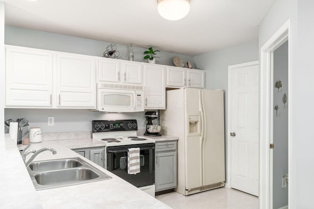 kitchen featuring light countertops, white appliances, a sink, and white cabinets