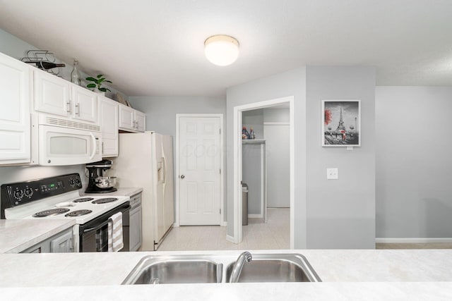 kitchen featuring white cabinets, white appliances, light countertops, and a sink