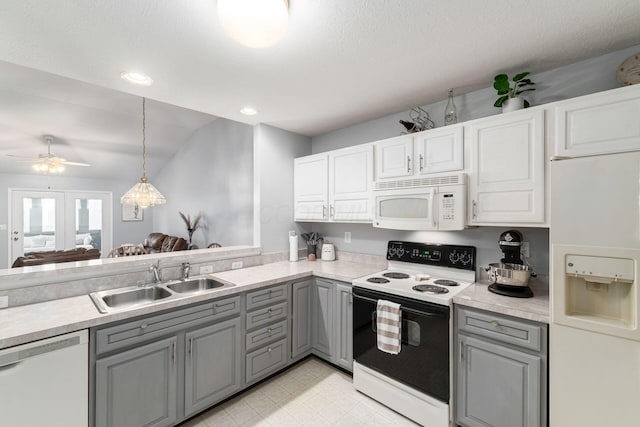 kitchen with light countertops, white appliances, a sink, and gray cabinetry