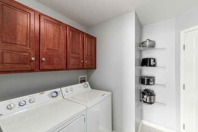 laundry area featuring cabinet space, washing machine and dryer, and a textured ceiling