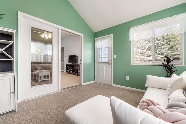 carpeted living room with lofted ceiling and baseboards