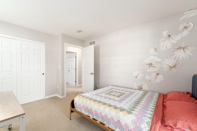 bedroom with light colored carpet, a closet, visible vents, and baseboards