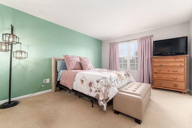 bedroom featuring lofted ceiling, baseboards, and light colored carpet