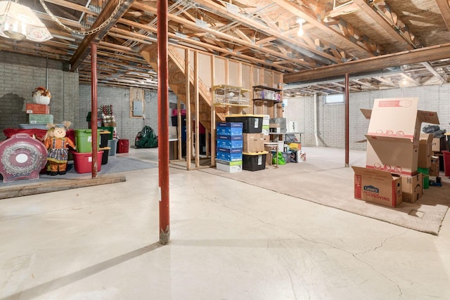 unfinished basement featuring brick wall and electric panel