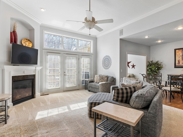 carpeted living room with crown molding, recessed lighting, a fireplace, french doors, and a ceiling fan