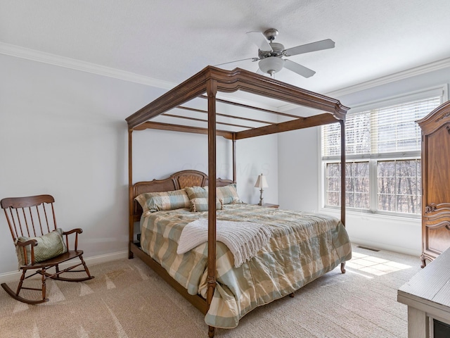 bedroom with visible vents, light carpet, ornamental molding, baseboards, and ceiling fan