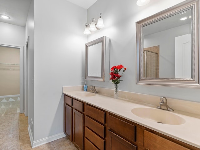 bathroom featuring a sink, a walk in closet, double vanity, and tile patterned flooring