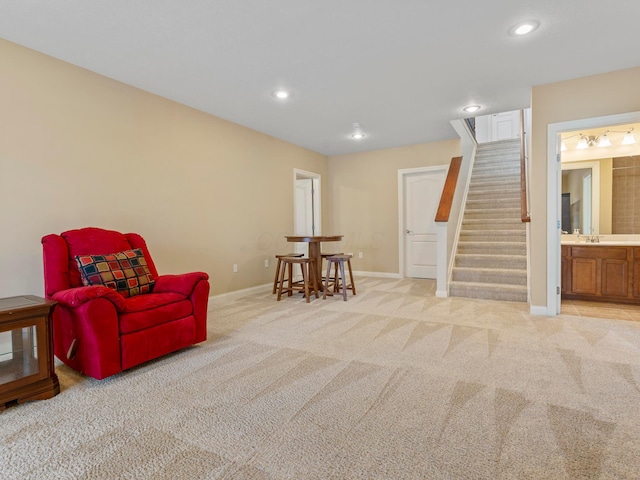 living area with recessed lighting, light colored carpet, stairs, and baseboards