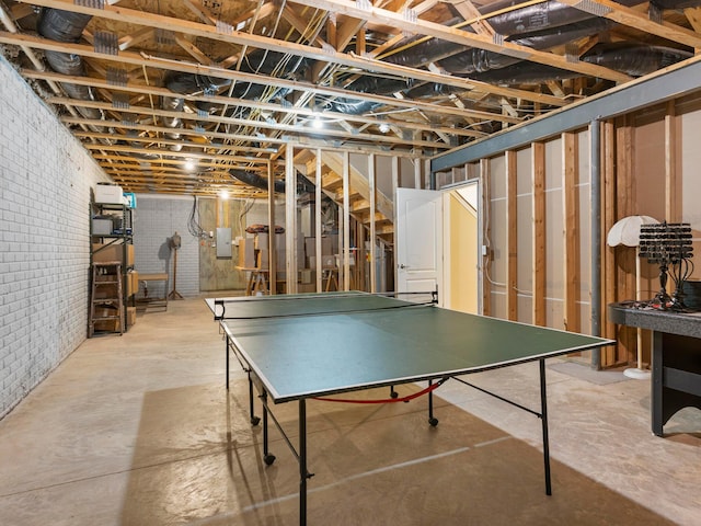 game room with electric panel, brick wall, and concrete floors