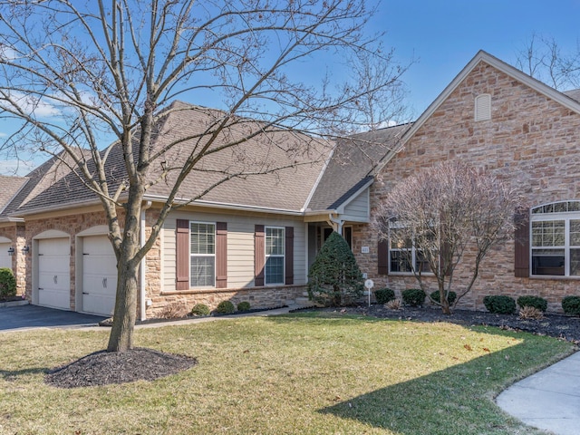 view of front of home with driveway, stone siding, a shingled roof, a front yard, and an attached garage