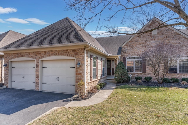 view of front of property featuring an attached garage, a front yard, driveway, and roof with shingles