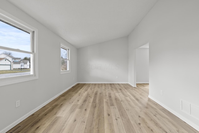 unfurnished room with baseboards, visible vents, and light wood-type flooring