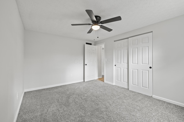 unfurnished bedroom with a closet, baseboards, carpet floors, and a textured ceiling