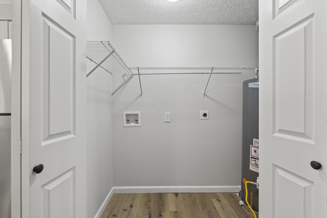 laundry room with electric dryer hookup, a textured ceiling, washer hookup, and wood finished floors