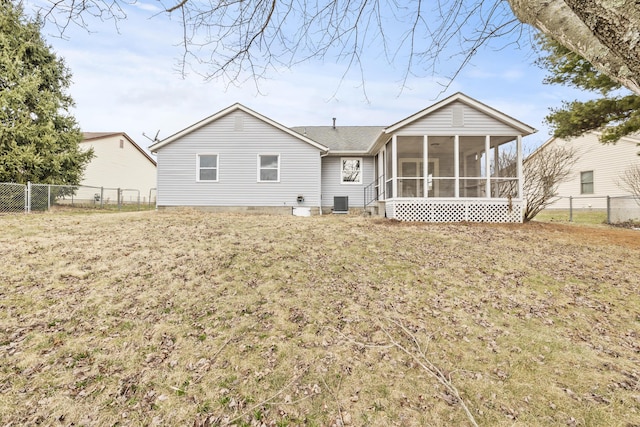 back of property featuring a yard, a fenced backyard, and a sunroom