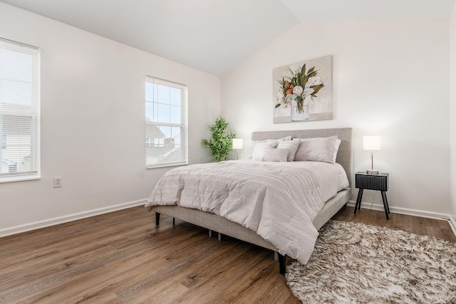 bedroom featuring vaulted ceiling, baseboards, and wood finished floors