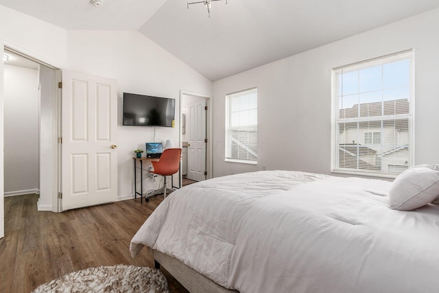 bedroom with lofted ceiling, baseboards, and wood finished floors