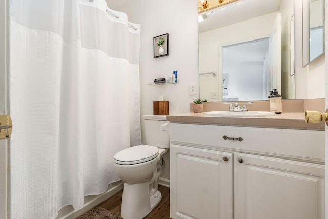 bathroom with vanity, toilet, and wood finished floors