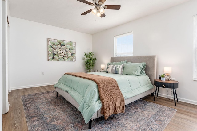 bedroom with ceiling fan, baseboards, and wood finished floors