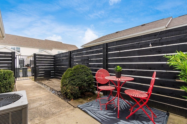 view of patio / terrace featuring central AC, a fenced backyard, and a gate