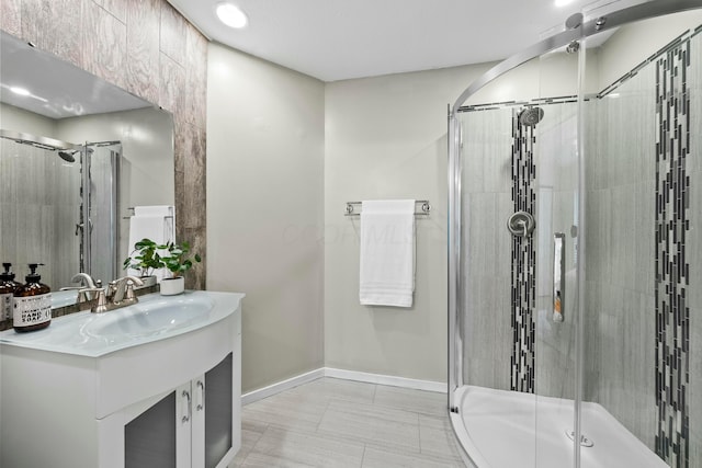 bathroom featuring a stall shower, baseboards, and vanity