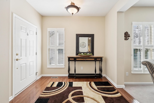 entrance foyer with visible vents, baseboards, and wood finished floors