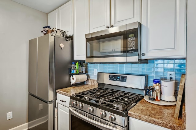 kitchen featuring stainless steel appliances, light countertops, white cabinetry, and tasteful backsplash